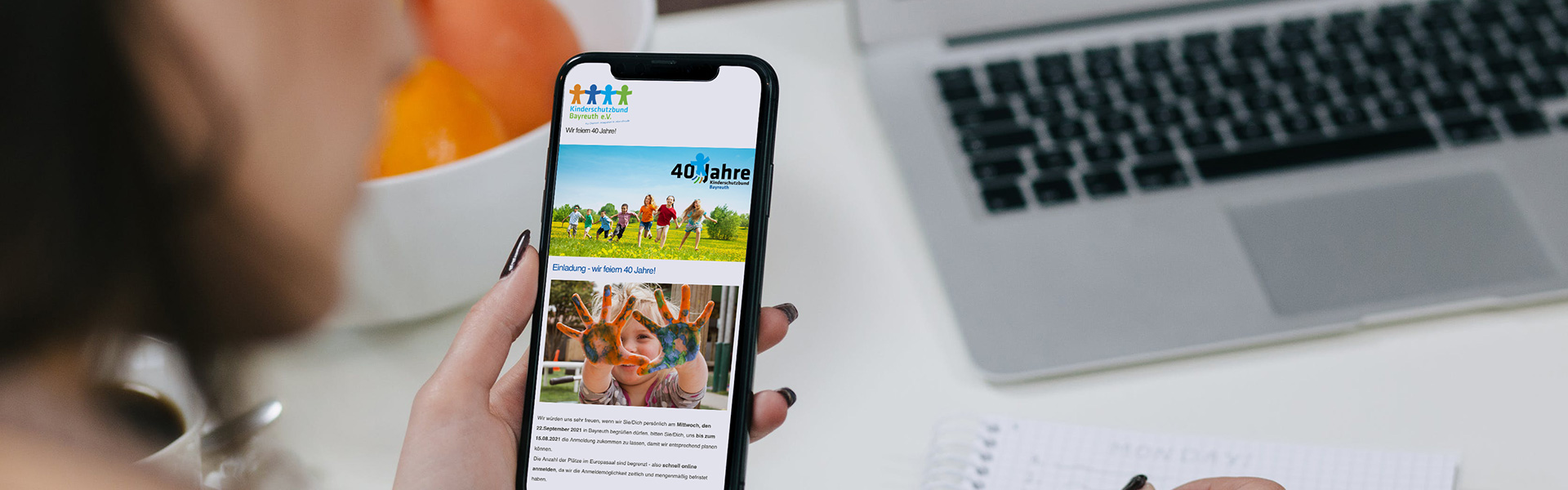 Frau blickt auf ein Handy mit dem Newsletter des Kinderschutzbunds Bayreuth